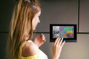 woman dials an apartment code on an electronic doorphone panel